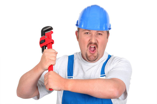 用扳手在工作服的工人