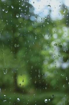 多雨的夏季的一天；在窗戶玻璃上的雨滴；宏觀特寫