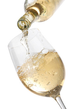 将白葡萄酒倒入玻璃杯；在白色背景上分离