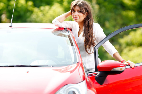 紅色轎車?yán)锏哪贻p漂亮女人