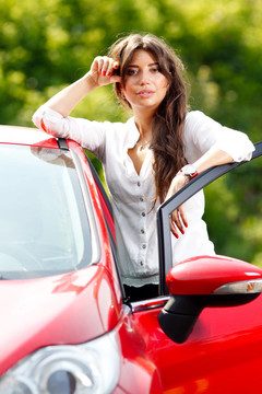 紅色轎車?yán)锏哪贻p漂亮女人