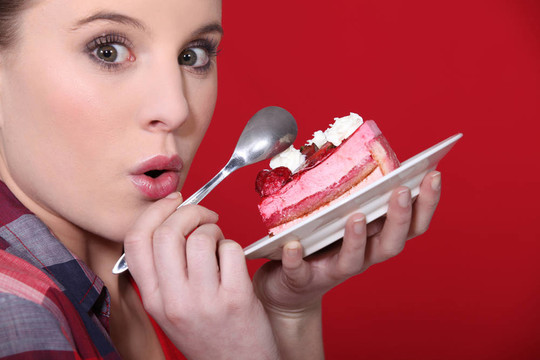 女孩沉浸在一块美味的草莓蛋糕