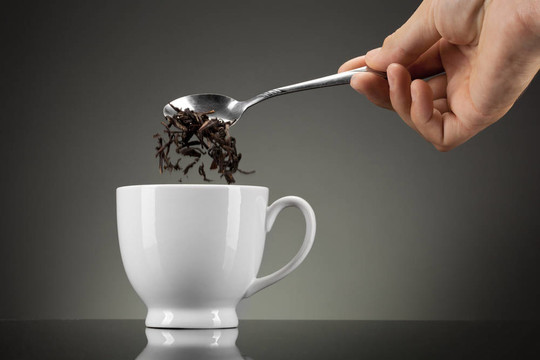 茶倒入灰色的白色杯子
