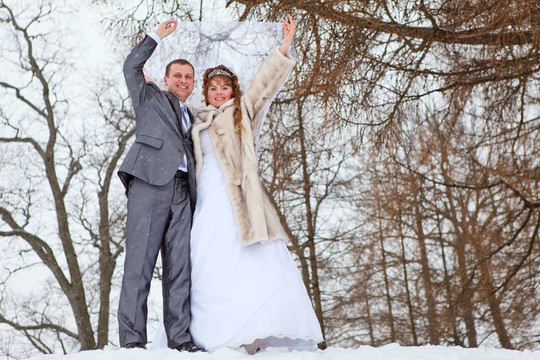 年輕的婚禮高加索夫婦在雪地公園散步。俄羅斯的冬季