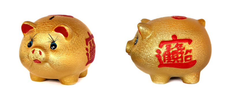 白色背景的金色小豬存錢罐。