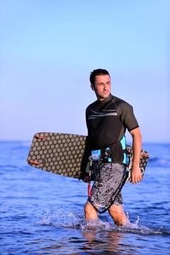 一个年轻人在海滩上的日落kitsurf肖像