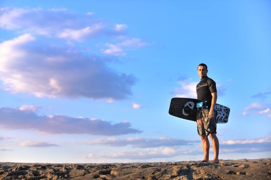 一個年輕人在海灘上的日落kitsurf肖像
