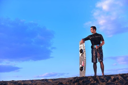 一個年輕人在海灘上的日落kitsurf肖像