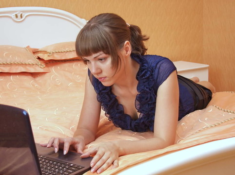 在床上有筆記本的女孩