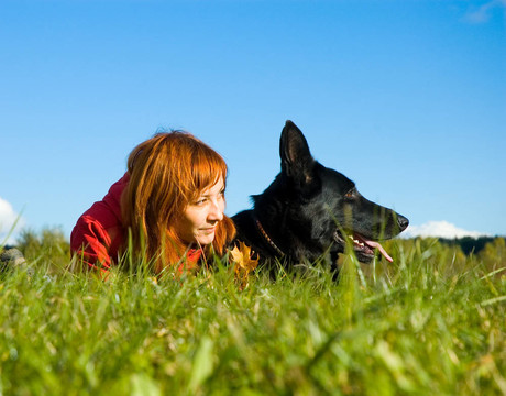 女人与她的狗在草地上。