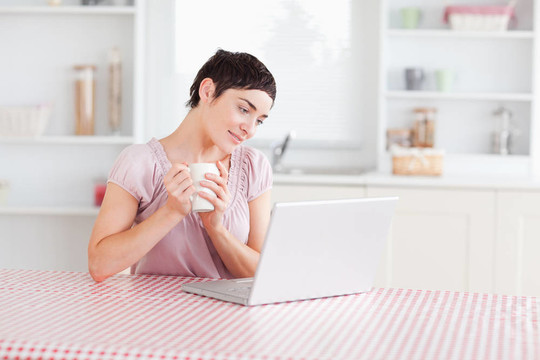 可愛的女人用筆記本拿著杯子