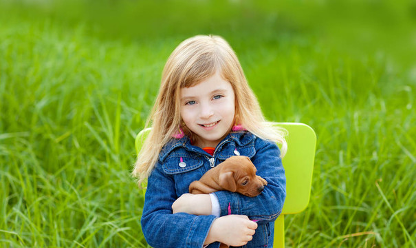 金发女孩与小狗宠物狗在绿草如茵