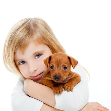 與小狗迷你杜賓犬的金發(fā)孩子的女孩