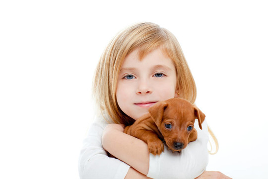 與小狗迷你杜賓犬的金發(fā)孩子的女孩