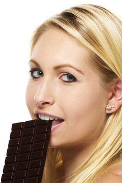 漂亮的金发女人在白色背景上吃巧克力