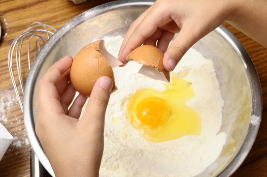 小孩把雞蛋掰成面粉