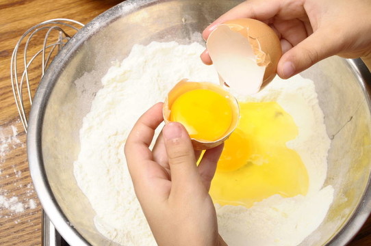 小孩把雞蛋掰成面粉