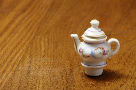 餐桌椅的孩子：在瓷茶壺在木桌上的縮影