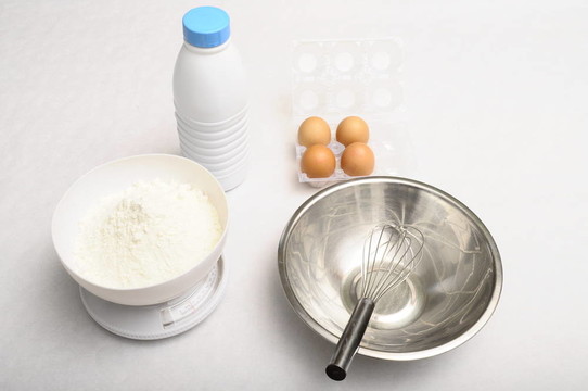 對于煎餅的烹飪原料和用具：牛奶；雞蛋；碗；平衡的食物；打上清晰的背景