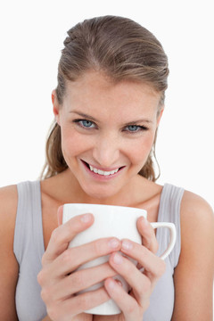 一個(gè)面帶微笑的女人舉著一杯茶的肖像