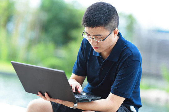 年輕人使用筆記本電腦戶外