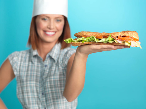 手上拿著一個大sadwich廚師