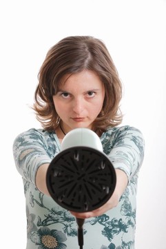 女人射用吹風(fēng)機(jī)