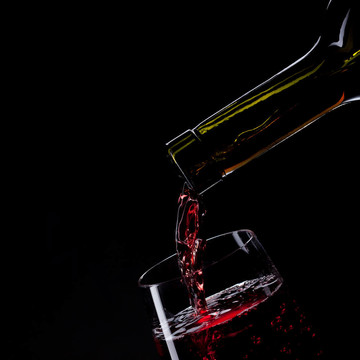 紅酒倒入黑色的酒玻璃