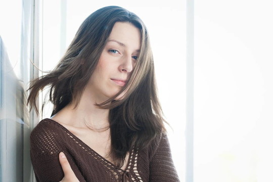漂亮的黑發(fā)女孩在窗口的肖像
