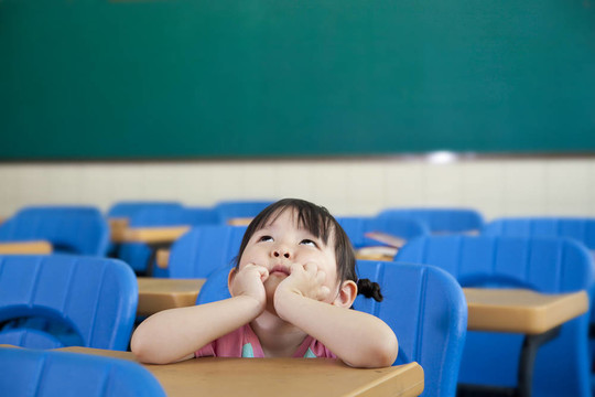 亞洲小女孩在教室里思考