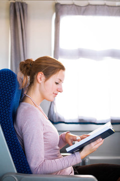 年輕女子在火車上看書