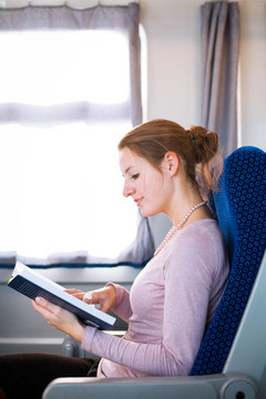 年輕女子在火車上看書