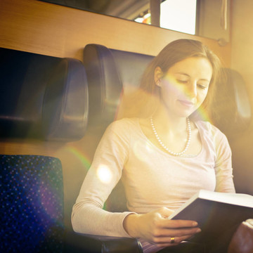 年輕女子在火車上看書