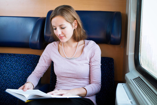 年輕女子在火車上看書