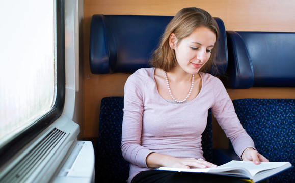 年輕女子在火車上看書