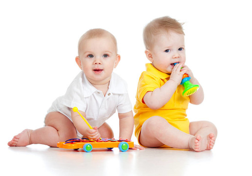 有趣的男孩與音樂玩具嬰兒。白色背景孤立