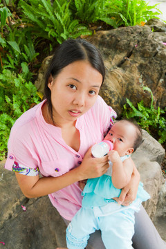 亞洲婦女喂養(yǎng)她的嬰兒頂部垂直
