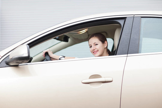 漂亮的年輕女人開著她的新車