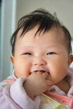 咬手指的快樂嬰兒
