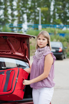 金發(fā)女人把她的行李裝進(jìn)汽車