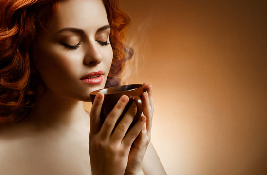 時髦的女人手上有芳香的咖啡