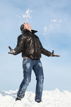 男人站在雪地上，雙手朝天空望去