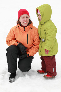 母親帶著女兒站在雪地上笑