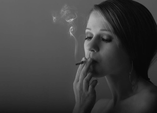 美麗的年輕女子抽香煙