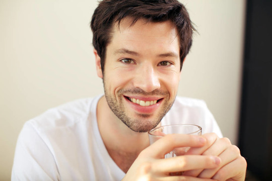 英俊的微笑男子與飲料