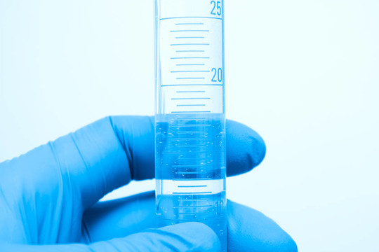 在研究實驗室里拿著玻璃試管的科學家手指