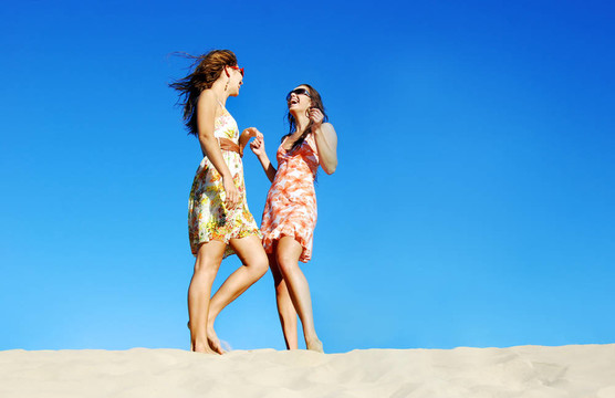 兩個年輕女人在夏日的海灘上玩得很開心