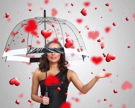 漂亮的年輕女人帶著雨傘和心
