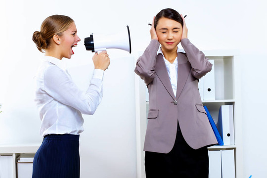 在辦公室用擴(kuò)音器的年輕女子