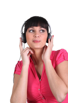 女人用耳機聽音樂